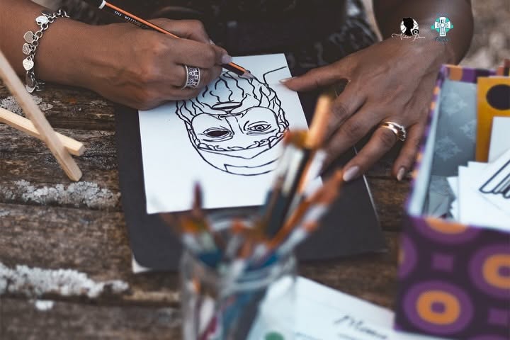 Una partecipante disegna un volto durante il laboratorio artistico