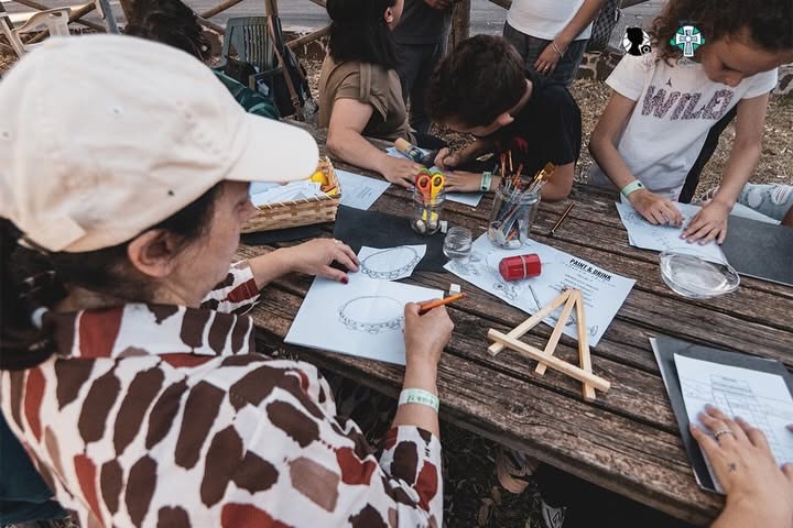 Partecipanti dipingono insieme nell’area verde del Museo Archeologico