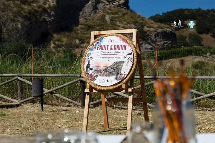 Il cartello dell’evento Paint & Drink – Calanna Edition nell’area verde del museo